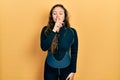 Young hispanic girl wearing diver neoprene uniform asking to be quiet with finger on lips