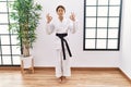 Young hispanic girl wearing karate kimono and black belt relax and smiling with eyes closed doing meditation gesture with fingers Royalty Free Stock Photo