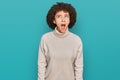 Young hispanic girl wearing wool winter sweater angry and mad screaming frustrated and furious, shouting with anger Royalty Free Stock Photo