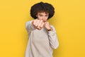 Young hispanic girl wearing wool winter sweater punching fist to fight, aggressive and angry attack, threat and violence Royalty Free Stock Photo