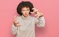 Young hispanic girl wearing wool winter sweater shouting frustrated with rage, hands trying to strangle, yelling mad Royalty Free Stock Photo