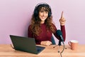 Young hispanic girl working at radio office smiling with an idea or question pointing finger up with happy face, number one