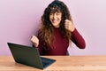 Young hispanic girl working using computer laptop celebrating surprised and amazed for success with arms raised and eyes closed Royalty Free Stock Photo