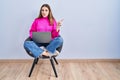 Young hispanic girl working using computer laptop pointing aside worried and nervous with forefinger, concerned and surprised Royalty Free Stock Photo