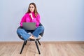 Young hispanic girl working using computer laptop thinking concentrated about doubt with finger on chin and looking up wondering Royalty Free Stock Photo