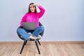 Young hispanic girl working using computer laptop very happy and smiling looking far away with hand over head Royalty Free Stock Photo