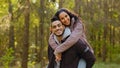 Young hispanic happy couple in love in autumn park handsome guy holding girl on back cute girlfriend hugging boyfriend Royalty Free Stock Photo