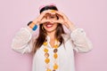 Young hispanic hippie woman wearing fashion boho style and sunglasses over pink background Doing heart shape with hand and fingers Royalty Free Stock Photo