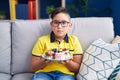 Young hispanic kid holding cake sweets relaxed with serious expression on face Royalty Free Stock Photo