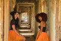 Young Hispanic and Latina women stand dressed for Halloween in the hallway of a dilapidated building