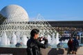 Young Hispanic male tourist taking pictures in the Epcot Disney Park during summer in Orlando