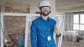 Young hispanic man architect smiling confident holding blueprints at construction site Royalty Free Stock Photo