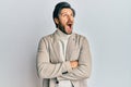 Young hispanic man with arms crossed gesture angry and mad screaming frustrated and furious, shouting with anger looking up Royalty Free Stock Photo