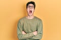 Young hispanic man with arms crossed gesture angry and mad screaming frustrated and furious, shouting with anger looking up Royalty Free Stock Photo