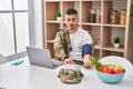 Young hispanic man army soldier using tensiometer at home