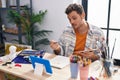 Young hispanic man artist having video call drawing at art studio