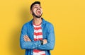 Young hispanic man with beard with arms crossed gesture angry and mad screaming frustrated and furious, shouting with anger Royalty Free Stock Photo