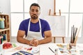 Young hispanic man with beard at art studio with painted face depressed and worry for distress, crying angry and afraid Royalty Free Stock Photo