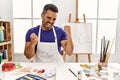 Young hispanic man with beard at art studio with painted face very happy and excited doing winner gesture with arms raised, Royalty Free Stock Photo