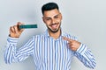 Young hispanic man with beard holding memory ram smiling happy pointing with hand and finger Royalty Free Stock Photo