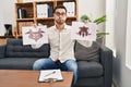 Young hispanic man with beard holding rorschach test puffing cheeks with funny face Royalty Free Stock Photo