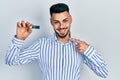 Young hispanic man with beard holding ssd memory smiling happy pointing with hand and finger Royalty Free Stock Photo