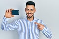 Young hispanic man with beard holding ssd memory smiling happy pointing with hand and finger Royalty Free Stock Photo