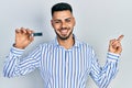 Young hispanic man with beard holding ssd memory smiling happy pointing with hand and finger to the side Royalty Free Stock Photo