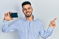 Young hispanic man with beard holding ssd memory smiling happy pointing with hand and finger to the side Royalty Free Stock Photo