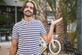 Young hispanic man with beard outdoors at the city smiling cheerful presenting and pointing with palm of hand looking at the Royalty Free Stock Photo