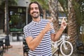 Young hispanic man with beard outdoors at the city smiling and looking at the camera pointing with two hands and fingers to the Royalty Free Stock Photo