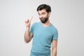 Young hispanic man with beard pointing with finger up and angry expression Royalty Free Stock Photo