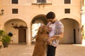 Young Hispanic man with beard and sunglasses hugging his dog standing very happy. Concept animals, dogs, love, pets, golden Royalty Free Stock Photo