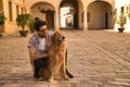 Young Hispanic man with beard and sunglasses hugging his dog very happy. Concept animals, dogs, love, pets. Royalty Free Stock Photo