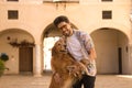 Young Hispanic man with beard and sunglasses looking at camera and hugging his dog who is standing very happy. Concept animals, Royalty Free Stock Photo