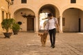 Young Hispanic man with beard and sunglasses walking with his dog very happy. Concept animals, dogs, love, pets, golden Royalty Free Stock Photo