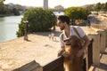 Young Hispanic man with beard, sunglasses and white shirt, leaning out with his dog leaning on a railing in funny attitude. Royalty Free Stock Photo