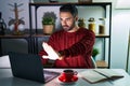 Young hispanic man with beard using computer laptop at night at home doing stop sing with palm of the hand Royalty Free Stock Photo