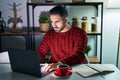 Young hispanic man with beard using computer laptop at night at home skeptic and nervous, frowning upset because of problem Royalty Free Stock Photo