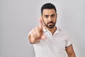 Young hispanic man with beard wearing casual clothes over white background pointing with finger up and angry expression, showing Royalty Free Stock Photo