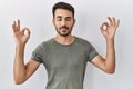 Young hispanic man with beard wearing casual t shirt over white background relax and smiling with eyes closed doing meditation Royalty Free Stock Photo