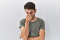 Young hispanic man with beard wearing casual t shirt over white background tired rubbing nose and eyes feeling fatigue and Royalty Free Stock Photo