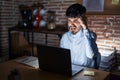 Young hispanic man with beard working at the office at night angry and mad raising fist frustrated and furious while shouting with Royalty Free Stock Photo