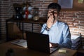 Young hispanic man with beard working at the office at night bored yawning tired covering mouth with hand Royalty Free Stock Photo