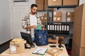 Young hispanic man with beard working at small business ecommerce thinking attitude and sober expression looking self confident Royalty Free Stock Photo