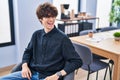 Young hispanic man business worker smiling confident sitting on chair at office Royalty Free Stock Photo