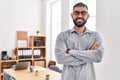 Young hispanic man business worker smiling confident standing with arms crossed gesture at office Royalty Free Stock Photo