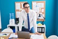 Young hispanic man business worker smiling confident standing by desk at office Royalty Free Stock Photo