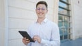 Young hispanic man business worker smiling confident using touchpad at hospital Royalty Free Stock Photo