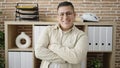Young hispanic man business worker standing with arms crossed gesture at office Royalty Free Stock Photo